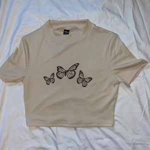 I am selling a tan butterfly cropped t-shirt. It is a size large.